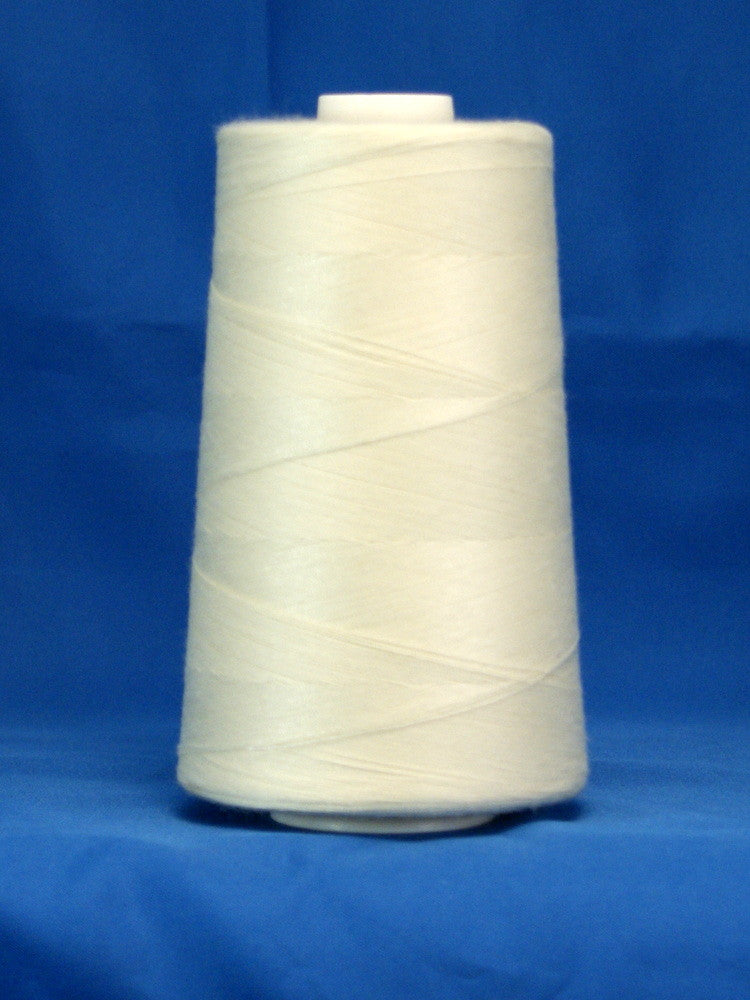 Natural colored thread wound on white cone spool against blue background