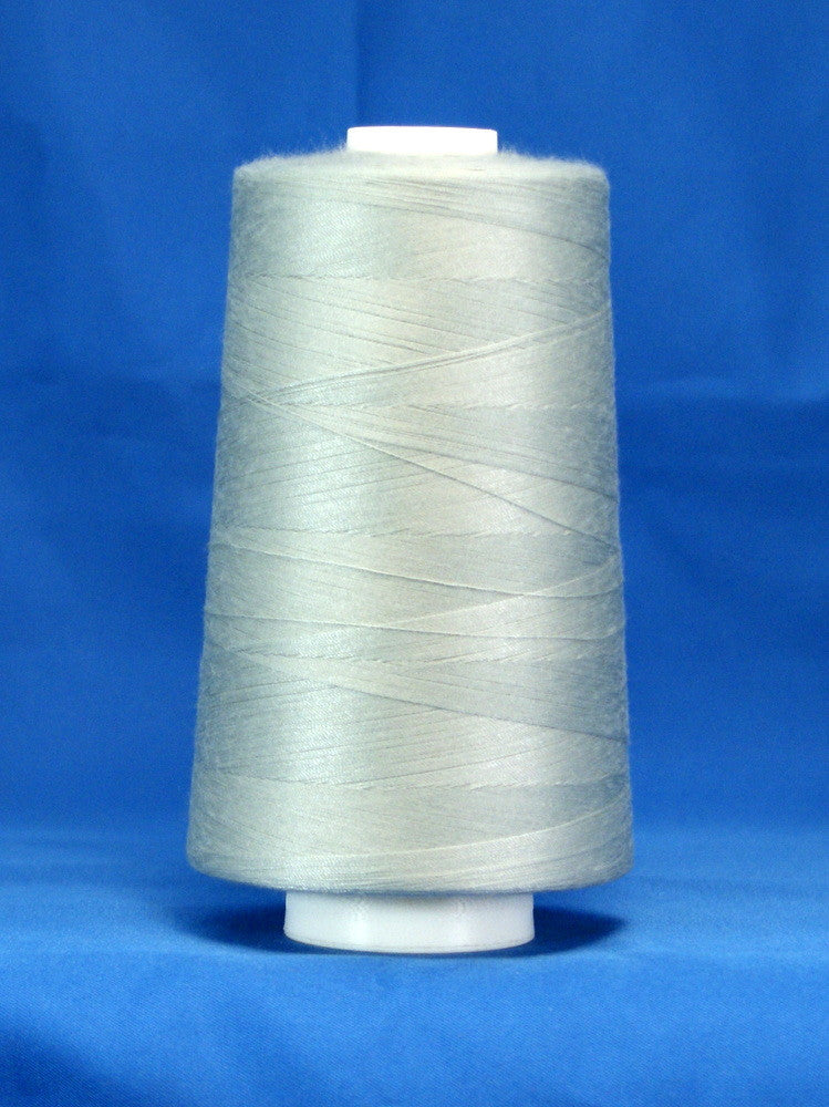 Silver thread wound on white plastic cone against blue background