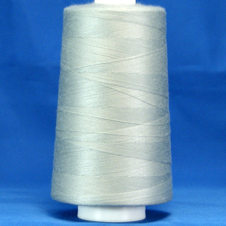 Silver thread wound on white plastic cone against blue background