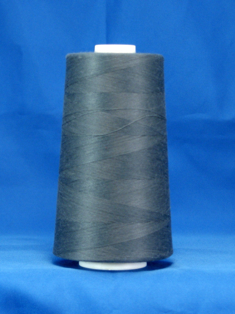 Storm grey thread wound on white plastic cone against bright blue background