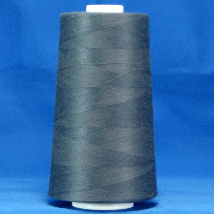 Storm grey thread wound on white plastic cone against bright blue background