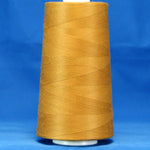 Golden brown thread wound on white plastic cone against blue background