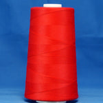 Red thread cone on white spool against blue background, tightly wound scarlet colored thread