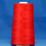 Red thread cone on white spool against blue background, tightly wound scarlet colored thread