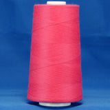 Fuschia pink thread wound on white plastic cone against blue background