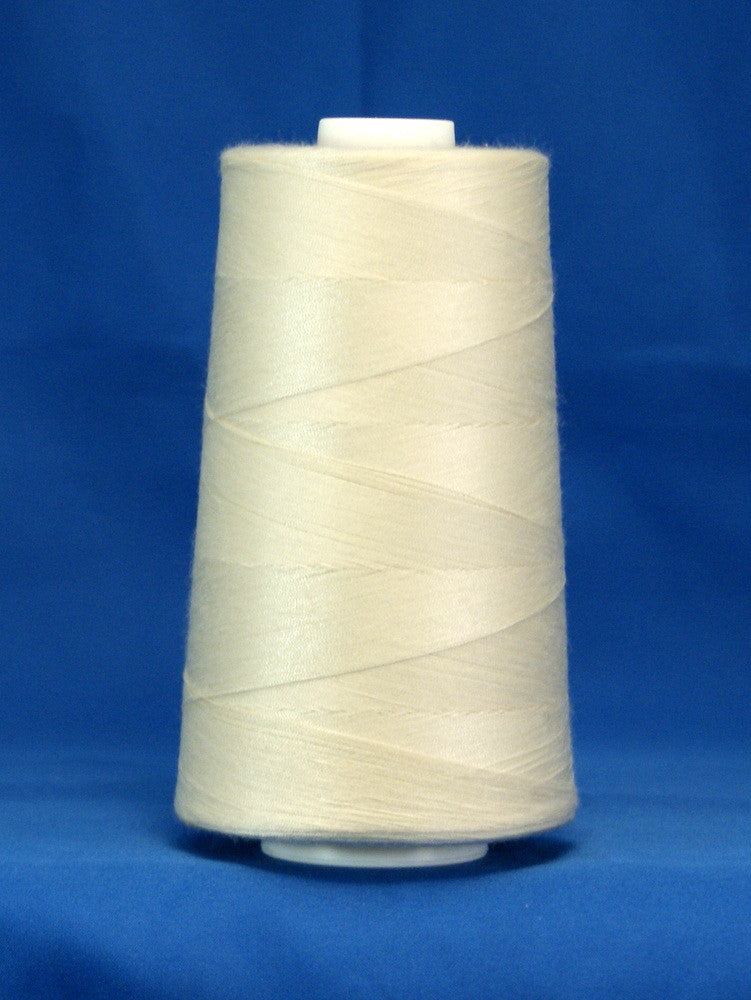 Off white thread wound on large industrial cone spool against blue background