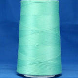 Aqua green thread wound on white plastic cone against blue background