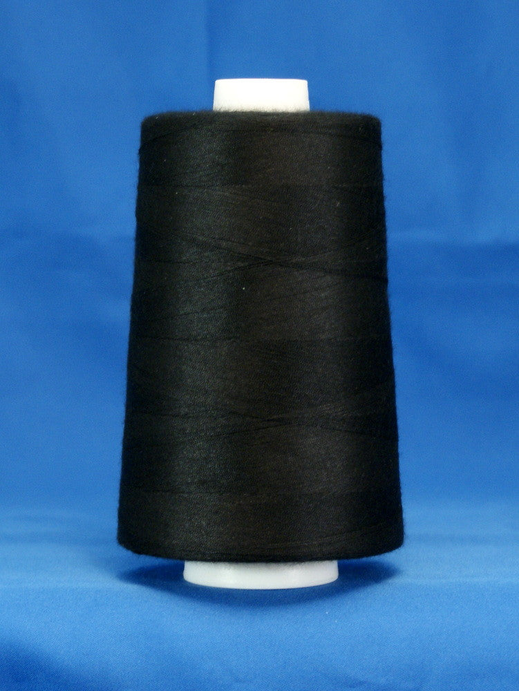 Black thread wound on white cone spool against blue background