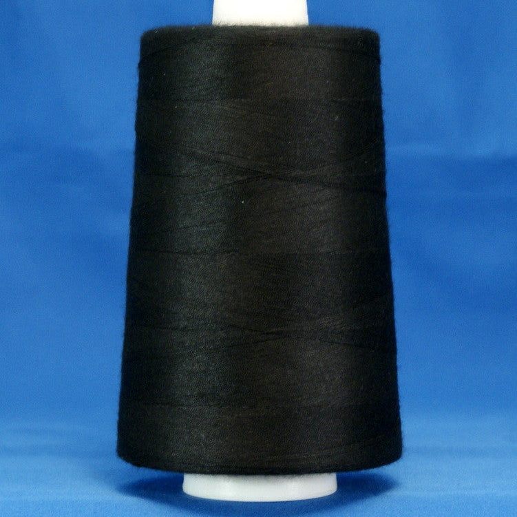 Black thread wound on white cone spool against blue background