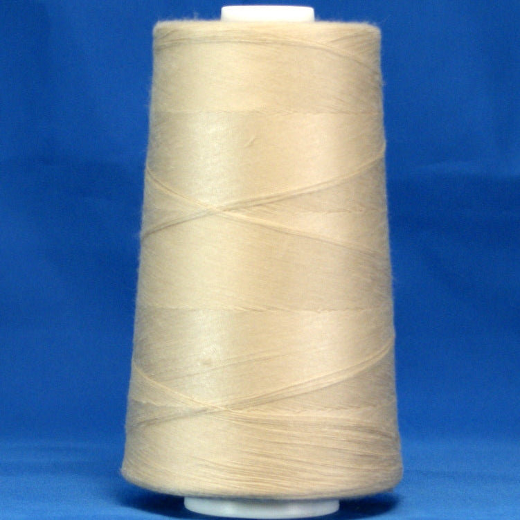 Khaki thread cone with beige-colored thread wound on white plastic spool against blue background