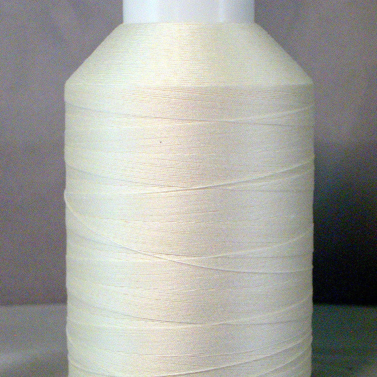 White thread cone spool with natural colored thread wound in horizontal layers