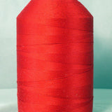 Red thread cone on white spool against light blue background