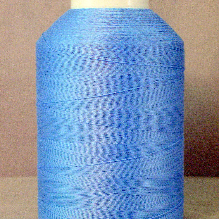 Light blue thread wound on white plastic cone spool