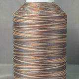 Variegated brown and tan thread on white cone spool with natural wood-like color pattern