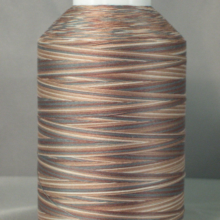 Variegated brown and tan thread on white cone spool with natural wood-like color pattern