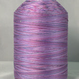 Purple variegated machine quilting thread on white cone, showing multicolored purple and pink striped pattern