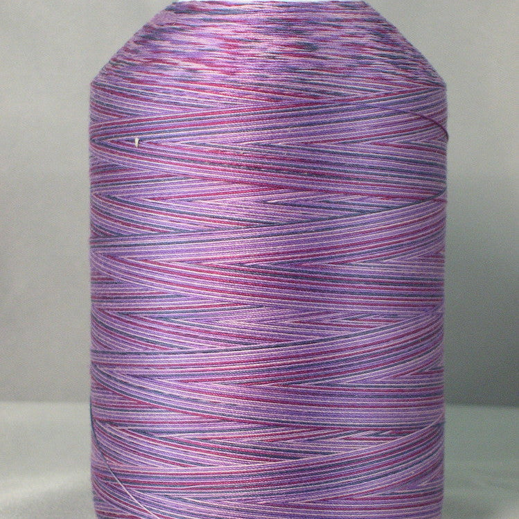 Purple variegated machine quilting thread on white cone, showing multicolored purple and pink striped pattern