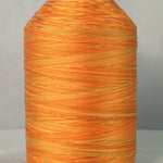 Variegated orange and gold quilting thread wound on white plastic cone
