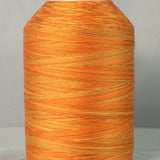 Variegated orange and gold quilting thread wound on white plastic cone