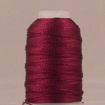 Wine colored rayon thread wound on white mini cone spool against neutral background