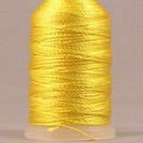 Yellow rayon thread on mini cone with cream plastic top and bottom, tightly wound with glossy finish