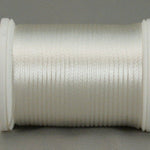 White rayon thread on white plastic spool, wound evenly with smooth lustrous finish