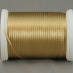 Gold rayon thread on white plastic spool, neatly wound with metallic sheen