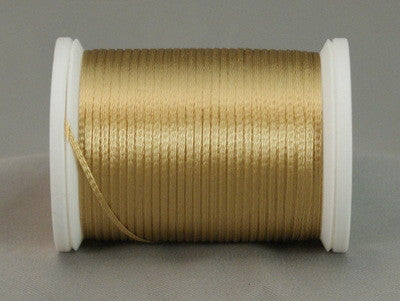 Gold rayon thread on white plastic spool, neatly wound with metallic sheen
