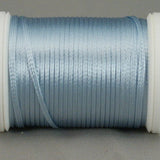 Pale blue rayon thread wound on white plastic spool with loose thread end visible