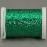 Green metallic quilting thread on white plastic spool with shimmery finish