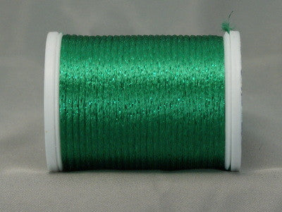 Green metallic rayon thread on white plastic spool, shimmery finish visible on wound thread