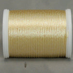 Soft yellow rayon thread with metallic highlights on white plastic spool