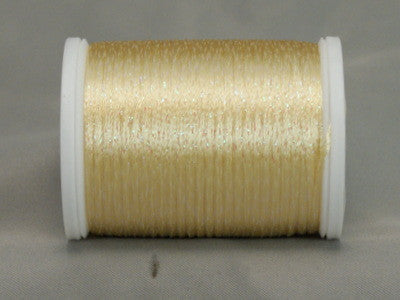 Soft yellow rayon thread with metallic highlights on white plastic spool