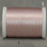 Soft pink metallic rayon thread on white plastic spool, showing shimmer and texture on neutral background