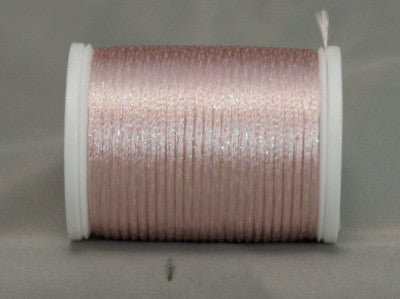 Soft pink metallic rayon thread on white plastic spool, showing shimmer and texture on neutral background