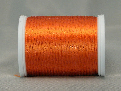 Orange and red rayon metallic thread on white plastic spool with glossy, shimmery finish
