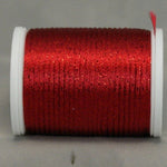 Wine red metallic thread on white plastic spool with loose thread end visible