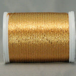 Golden metallic thread on white plastic spool with shimmery copper highlights