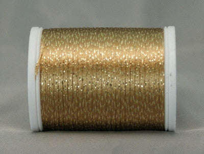 Gold metallic thread on white plastic spool, shimmery finish with tightly wound layers