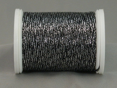 Black and silver metallic thread on white plastic spool, twisted rayon and metallic fibers creating shimmery texture