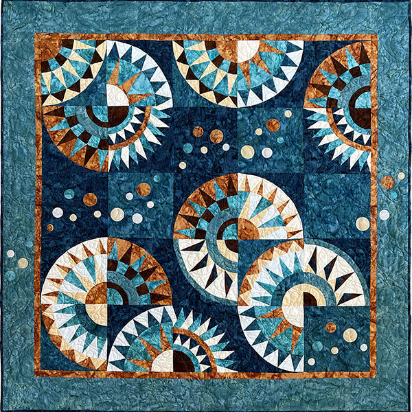Batik quilt kit featuring curved spiral designs in teal, navy, rust orange and cream colors with geometric triangular patterns and circular motifs
