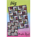Colorful quilt pattern featuring geometric blocks with vibrant florals and contrasting black sashing, displayed on gradient green-to-pink background.