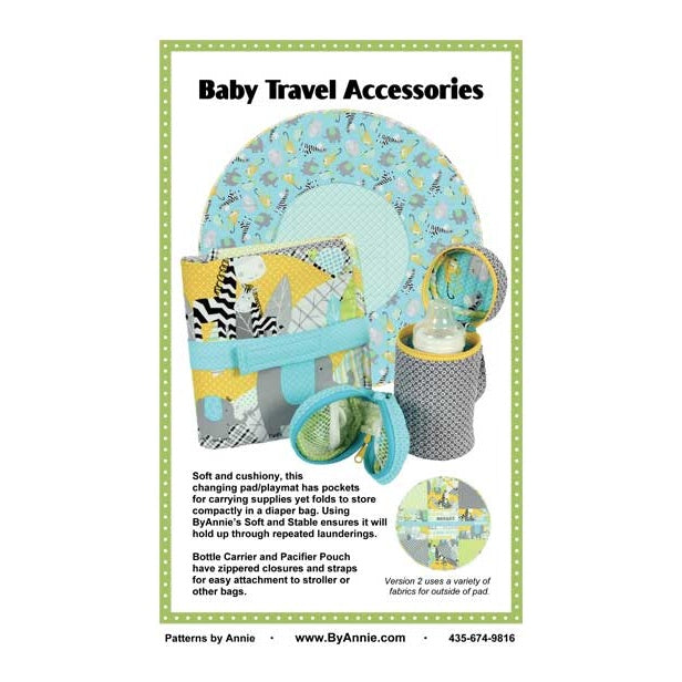 Colorful baby travel accessories including a changing pad, diaper bag, and storage containers in blue, yellow, and gray patchwork patterns with cute animal prints.
