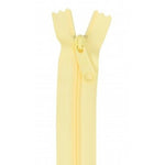 A pale yellow 24-inch zipper with matching tape and pull tab in a butter cream color.