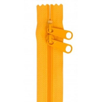Bright orange 30-inch zipper with two matching pull tabs and decorative scalloped tape edge.