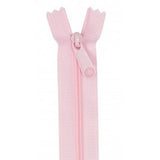 Pale pink zipper with plastic teeth and matching pull tab, displayed vertically against white background.