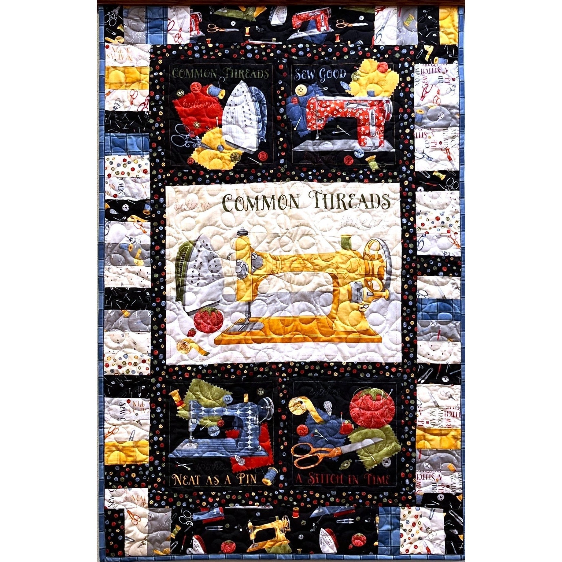 A colorful quilt featuring vintage sewing machine motifs with text panels reading "Common Threads," "Sew Good," "Neat as a Pin," and "A Stitch in Time.