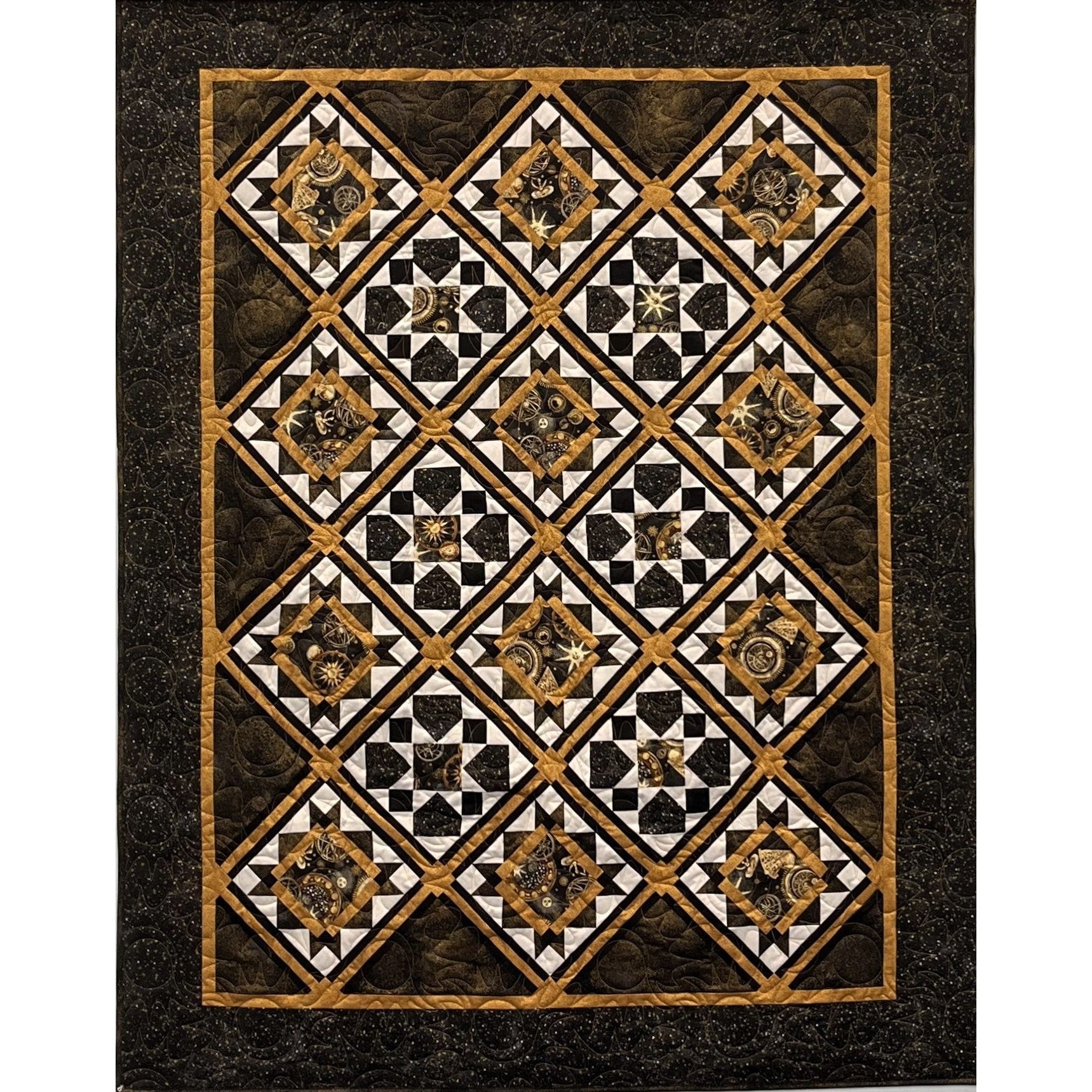 A geometric quilt with black, gold, and cream diamond and star patterns arranged in a grid on a dark speckled background.