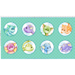 Colorful fabric panel featuring eight cute cartoon dragon faces in circles on a green geometric background with measurement ruler along the top.