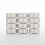 Twelve clear plastic bobbins of light gray thread arranged in a 4x3 grid, each filled with fine polyester thread
